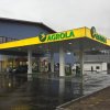 AGROLA Tankstelle in Zweisimmen, Bern, mit TopShop, regnerische Aufnahme, Vorplatz - nass, Tankstelle angeschlossen an blauem Gebäude