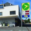 AGROLA Tankstelle in Kirchlindach; eine Tanksäule links bei Hauswand; im Vordergrund Totem mit AGROLA Logo, Preisen und Volg-Schild