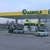AGROLA Tankstelle in Koppigen. Überdacht mit zwei Tanksäulen. Im Hintergrund eine selfwash Autowaschanlage. Zwei weisse Autos bei den Tanksäulen