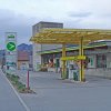 AGROLA Tankstelle in Urnäsch; gelbes Glasdach; im Hintergrund Beton-gebäude von Landi