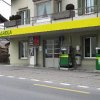 AGROLA Tankstelle in St. Erhard - Knutwil; zwei Tanksäulen mit Zahlterminal und digitaler Preisanzeige; an Wohnhaus gelegen; über AGROLA Dach direkt Balkon von Wohnhaus